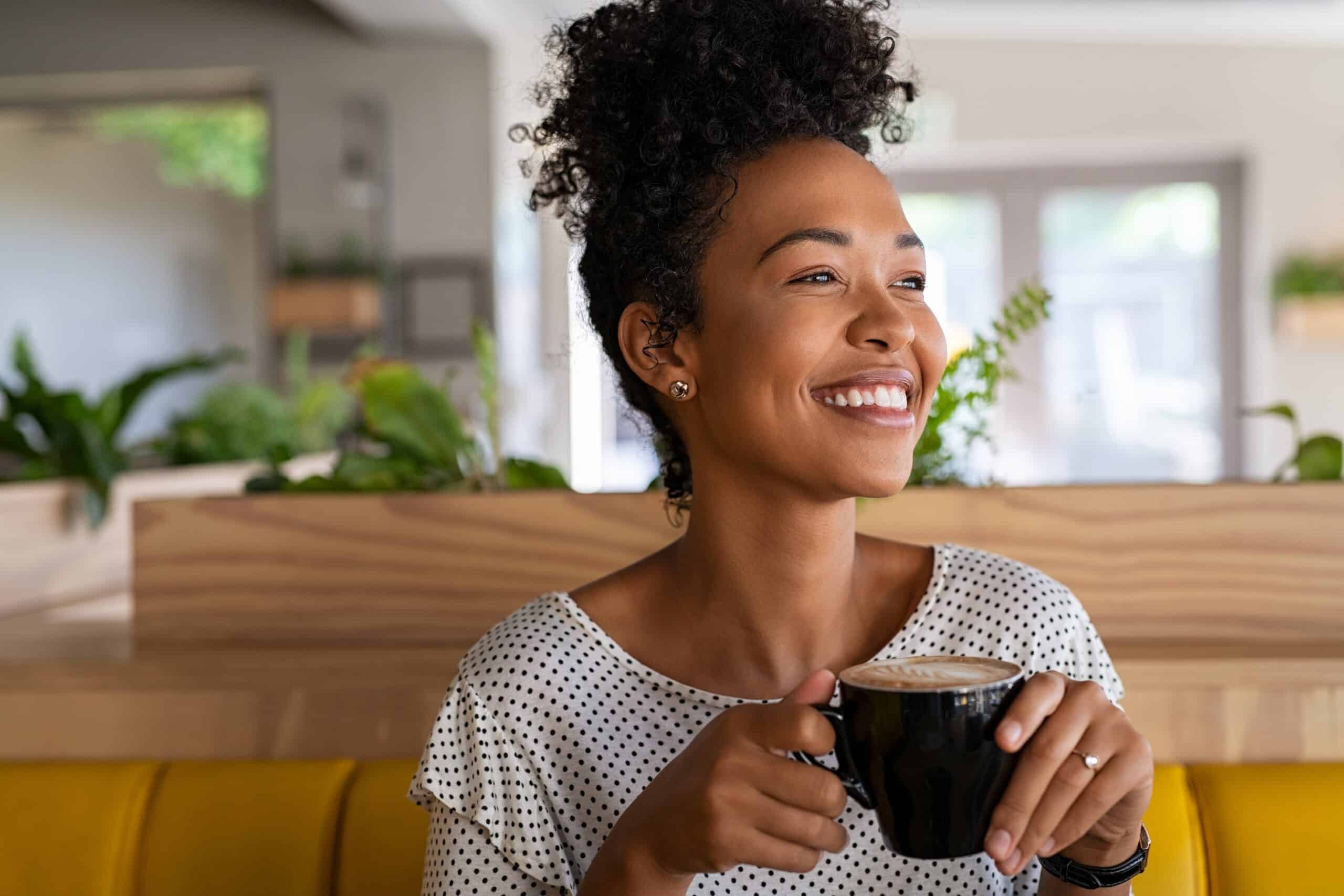 Carefree,African,American,Woman,Sitting,In,Cafeteria,Drinking,Coffee,While